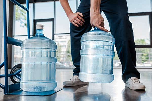 Man lifting a heavy 5 gallon water jug